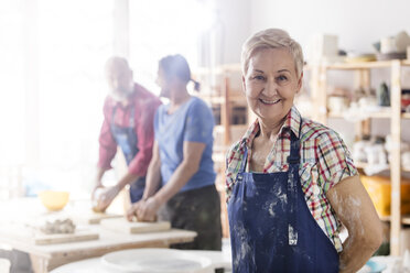 Portrait smiling senior woman in pottery studio - CAIF08650