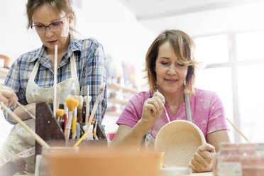 Reife Frauen malen Töpferwaren im Atelier - CAIF08668