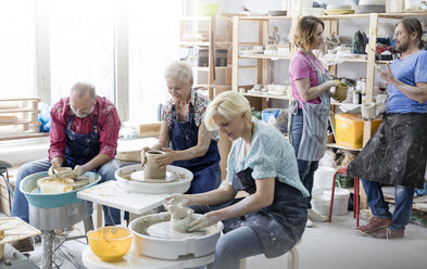 Ältere Schüler benutzen Töpferscheiben im Atelier - CAIF08674