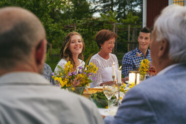 Woman enjoying family garden party dinner - CAIF08716