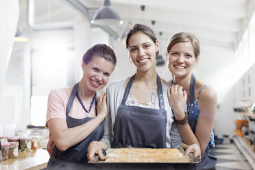 Porträt lächelnde Freundinnen genießen Kochkurs in der Küche - CAIF08725