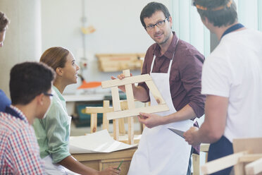 Teacher and students in adult education carpentry workshop class - CAIF08794