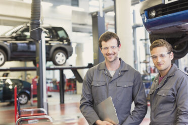 Portrait confident mechanics in auto repair shop - CAIF08800