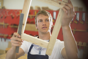 Schreiner untersucht Holz in der Werkstatt - CAIF08821