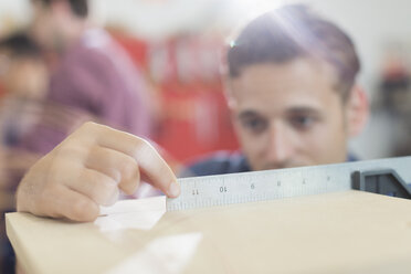 Close up carpenter measuring wood with ruler - CAIF08824