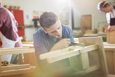 Schreiner beim Messen und Anzeichnen von Holz in der Werkstatt - CAIF08830