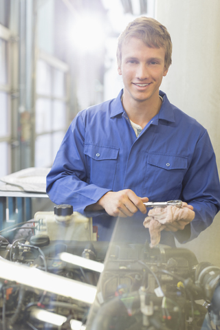 Porträt selbstbewusster Mechaniker bei der Arbeit am Motor in einer Autowerkstatt, lizenzfreies Stockfoto