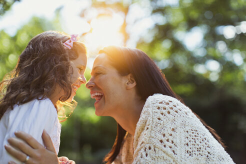 Enthusiastische Mutter und Tochter lächeln von Angesicht zu Angesicht - CAIF08842