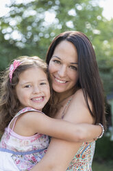 Portrait smiling mother holding daughter - CAIF08847