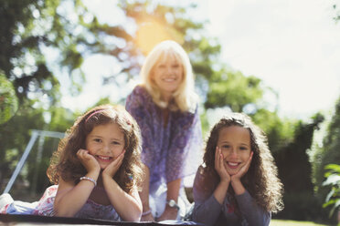 Porträt lächelnde Großmutter mit Zwillings-Enkelinnen im Park - CAIF08856