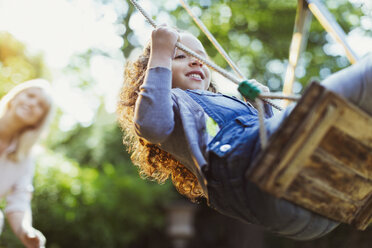 Carefree girl swinging in park - CAIF08859