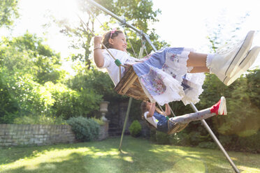 Carefree girls swinging in backyard - CAIF08869