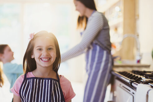 Porträt begeistertes Mädchen mit zahnigem Lächeln in der Küche - CAIF08887
