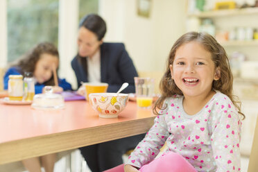 Porträt begeistertes Mädchen am Frühstückstisch - CAIF08926