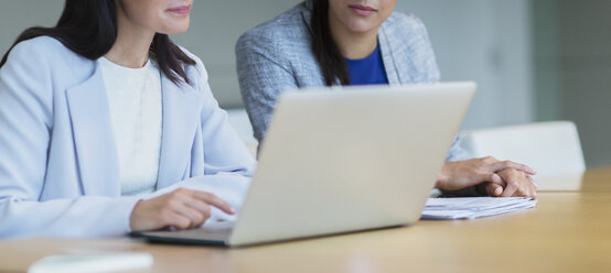 Geschäftsfrauen arbeiten an einem Laptop in einem Konferenzraum - CAIF08973