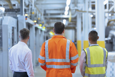 Arbeiter und Aufseher stehen in einem Fabrikkorridor - CAIF09039