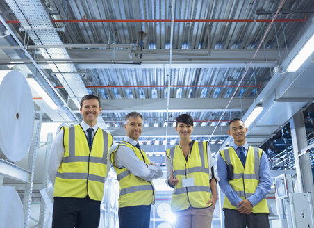 Portrait lächelnde Arbeiter in reflektierender Kleidung in einer Fabrik - CAIF09062