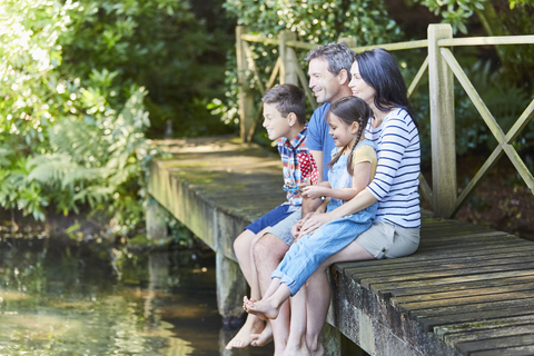 Die Familie sitzt am Rande des Stegs, lizenzfreies Stockfoto