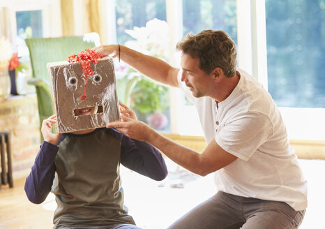 Vater setzt seinem Sohn eine Robotermaske auf - CAIF09141