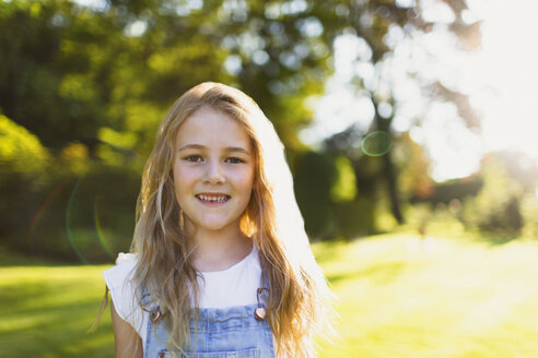 Portrait lächelndes Mädchen im sonnigen Garten - CAIF09151