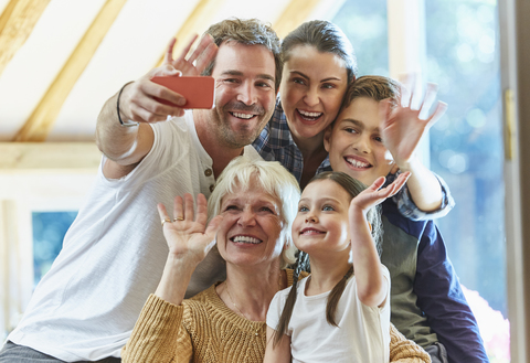 Mehrgenerationenfamilie winkt und macht ein Selfie, lizenzfreies Stockfoto