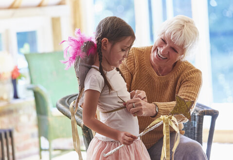 Grandmother fitting granddaughter with wings - CAIF09170