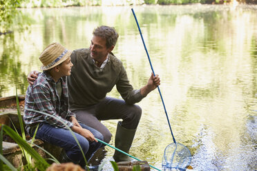 Vater und Sohn fischen mit Netzen in einem Teich - CAIF09174