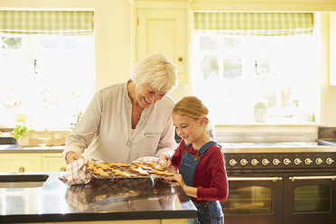 Großmutter und Enkelin backen Lebkuchen in der Küche - CAIF09202