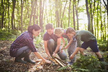 Familie baut Lagerfeuer im Wald - CAIF09205