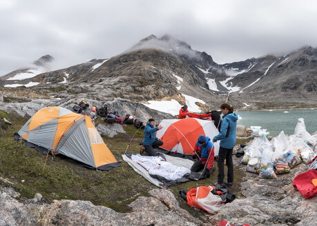 Greenland, Sermersooq, Kulusuk, Schweizerland Alps, group of people setting up camp - ALRF00923