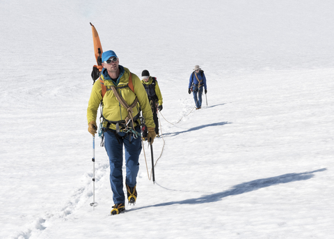 Grönland, Sermersooq, Kulusuk, Schweizerland Alpen, Gruppe von Menschen zu Fuß im Schnee, lizenzfreies Stockfoto