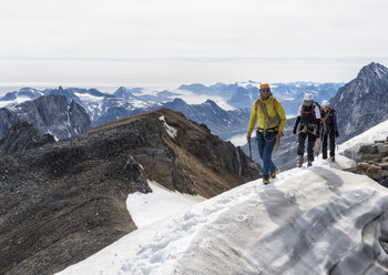 Grönland, Sermersooq, Kulusuk, Schweizerland Alpen, Bergsteiger beim Wandern in verschneiter Berglandschaft - ALRF00949