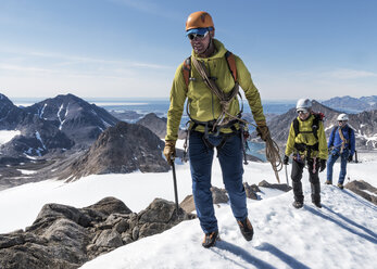 Greenland, Sermersooq, Kulusuk, Schweizerland Alps, mountaineers walking in snowy mountainscape - ALRF00950