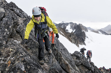 Grönland, Sermersooq, Kulusuk, Schweizerland Alpen, Bergsteiger beim Aufstieg auf einen felsigen Berg - ALRF00958