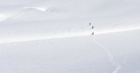 Greenland, Sermersooq, Kulusuk, Schweizerland Alps, three people walking in snow - ALRF00981