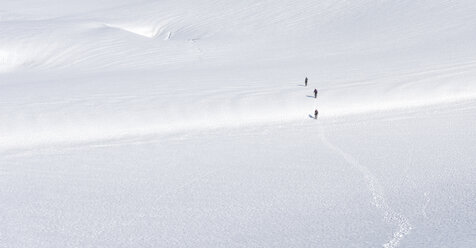 Grönland, Sermersooq, Kulusuk, Schweizerland Alpen, drei Personen beim Wandern im Schnee - ALRF00981