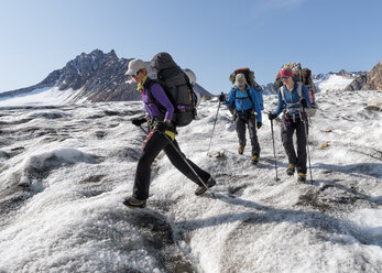 Greenland, Sermersooq, Kulusuk, Schweizerland Alps, three people walking in snowy mountainscape - ALRF00984