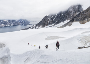 Greenland, Sermersooq, Kulusuk, Schweizerland Alps, group of people walking in snow - ALRF00992