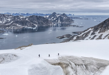 Greenland, Sermersooq, Kulusuk, Schweizerland Alps, three people walking in snow - ALRF00996