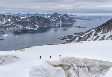 Grönland, Sermersooq, Kulusuk, Schweizerland Alpen, drei Personen beim Wandern im Schnee - ALRF00996
