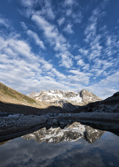 Grönland, Sermersooq, Kulusuk, Schweizerland Alpen, Mann steht an einem See mit sich im Wasser spiegelnden Bergen - ALRF01001
