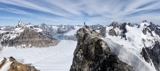 Greenland, Sermersooq, Kulusuk, Schweizerland Alps, mountaineer with raised arms on summit - ALRF01005