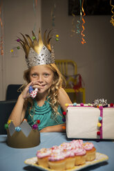 Portrait of smiling girl holding party horn blower - CAVF04098