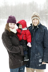 Porträt einer Familie auf einem schneebedeckten Feld - CAVF04204