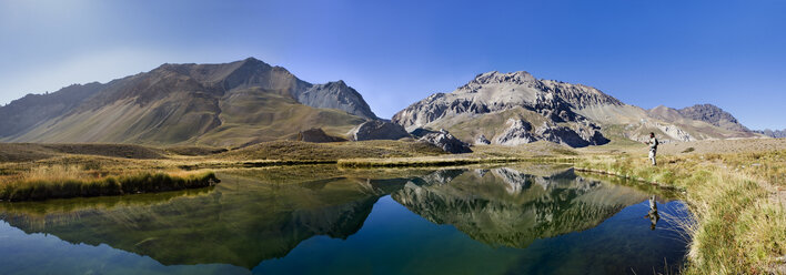 Panoramic view of lake by mountain against clear blue sky - CAVF04232