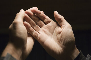 Cropped image of man hands against black background - CAVF04234