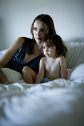 Mutter und Tochter schauen weg, während sie sich zu Hause auf dem Bett entspannen - CAVF04274