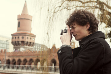 Mann fotografiert an der Oberbaumbrücke stehend - CAVF04326