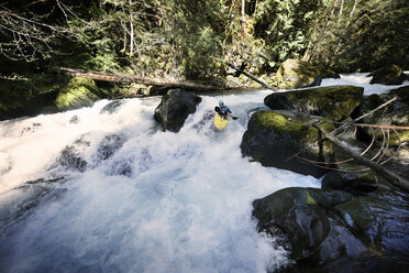 Mann fährt Kajak auf einem Fluss im Wald - CAVF04337