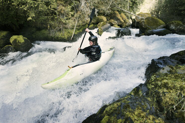 Mann balanciert beim Kajakfahren auf dem Fluss - CAVF04349